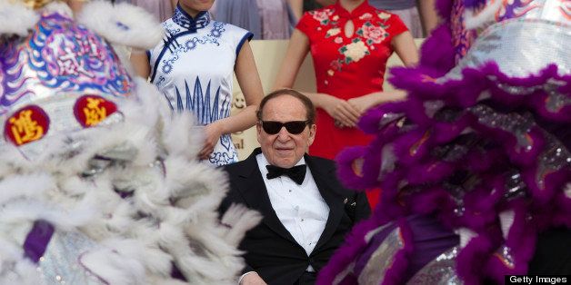 FILE PHOTO: 'BEST PHOTOS OF 2012' (***BESTOF2012***): Sheldon Adelson, chairman and chief executive officer of Las Vegas Sands Corp., center, watches a traditional lion dance during the opening of the Sands Cotai Central resort in Macau, China, on Wednesday, April 11, 2012. Adelson plans to spend $35 billion on building Spanish gambling resorts over nine years and will add a new Macau location to expand globally. Photographer: Jerome Favre/Bloomberg via Getty Images 