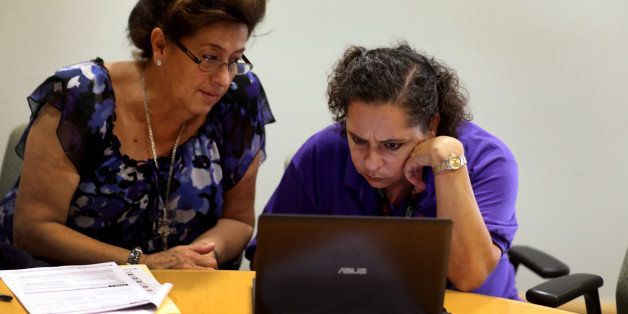 MIAMI, FL - OCTOBER 08: Affordable Care Act navigator Nini Hadwen (R) works with Marta Aguirre as she shops for health insurance during a navigation session put on by the Epilepsy Foundation Florida to help people sign up for health insurance under the Affordable Care Act on October 8, 2013 in Miami, Florida. The United States government continues to be partially shut down as Republicans hold out hope to cut funding for the Affordable Care Act. (Photo by Joe Raedle/Getty Images)