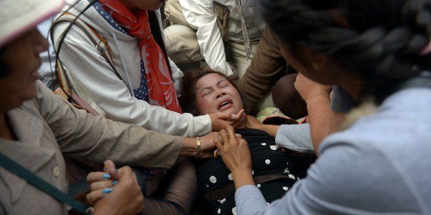 A Cambodian land rights activist faints during a protest in Phnom Penh on January 21, 2014. Cambodian police detained 11 activists on January 21 as they broke up a rally calling for international assistance to secure the release of protesters arrested during a recent bloody crackdown, witnesses said. AFP PHOTO/ TANG CHHIN SOTHY (Photo credit should read TANG CHHIN SOTHY/AFP/Getty Images)