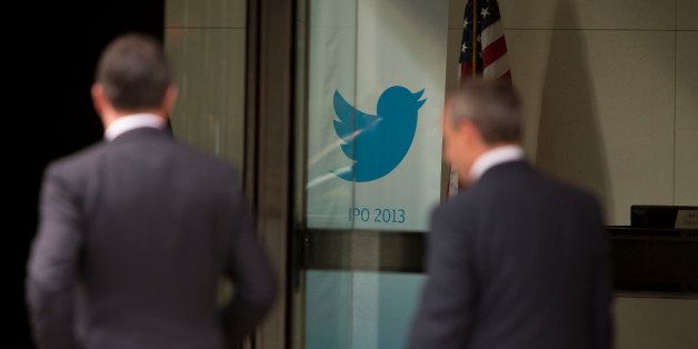 Men walk past the Twitter Inc. logo displayed in the lobby of JPMorgan Chase & Co. headquarters in New York, U.S., on Friday, Oct. 25, 2013. Twitter Inc. will make the case to potential investors in its initial public offering that it needs to keep spending to grow, and profit will come once it can reap the benefits of those investments. Photographer: Scott Eells/Bloomberg via Getty Images