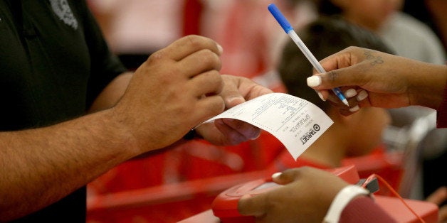 MIAMI, FL - DECEMBER 19: A customer prepares to sign a credit card slip at a Target store on December 19, 2013 in Miami, Florida. Target announced that about 40 million credit and debit card accounts of customers who made purchases by swiping their cards at terminals in its U.S. stores between November 27 and December 15 may have been stolen. (Photo by Joe Raedle/Getty Images)