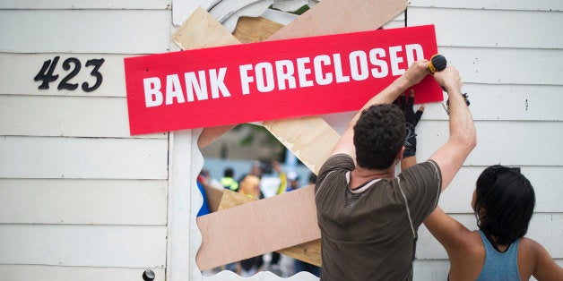 Protesters work on a prop in Freedom Plaza as they prepare for a rally against big banks and home foreclosures in Washington, DC, May 20, 2013. AFP PHOTO/JIM WATSON (Photo credit should read JIM WATSON/AFP/Getty Images)