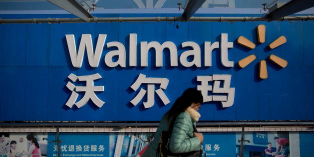 A woman walks past signage for a Wal-Mart Stores Inc. store in the Shekou district of Shenzhen, China, on Thursday, Dec. 19, 2013. Two of Chinas three biggest securities firms predict the central bank will refrain from using open-market operations to inject funds this week as policy makers seek to rein in debt and contain inflation. Photographer: Brent Lewin/Bloomberg via Getty Images