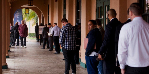 Job seekers line up for the Recruit Military veteran job fair in San Diego, California, U.S., on Thursday, Feb. 27, 2014. More Americans than forecast filed applications for unemployment benefits last week, a sign the labor market is improving in fits and starts. Photographer: Sam Hodgson/Bloomberg via Getty Images