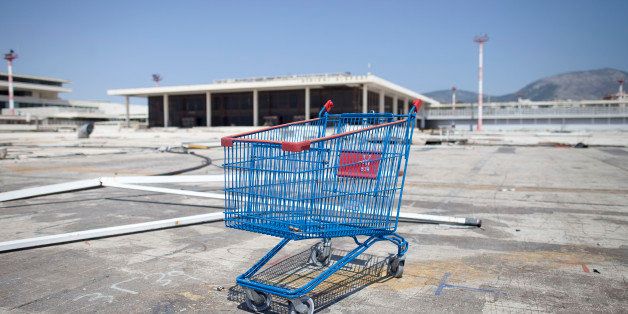 A shopping cart stands on a disused runway near an abandoned terminal building at the former international airport, operated by Hellenikon SA, in Athens, Greece, on Wednesday, May 2, 2012. Greece received expressions of interest from nine groups to buy a majority stake in Hellenikon SA, which will develop and exploit the site of the former Athens International Airport, the Athens-based Hellenic Republic Asset Development Fund said in an e-mailed statement. Photographer: Simon Dawson/Bloomberg via Getty Images