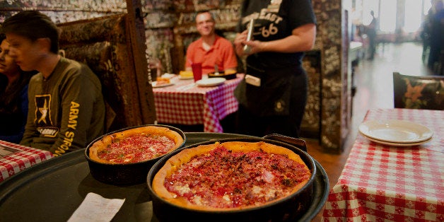 A waitress carries deep dish pizzas to customers at Gino's East restaurant in Chicago, Illinois, U.S., on Wednesday, April 18, 2012. U.S. restaurant-industry sales for a typical day in 2012 are estimated to be $1.7 billion, according to the National Restaurant Association. Photographer: Daniel Acker/Bloomberg via Getty Images