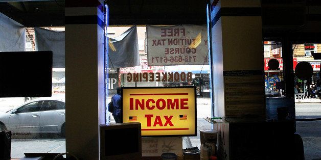 NEW YORK - APRIL 15: A, 'Income Tax' sign sits in window of the Liberty Tax Service April 15, 2010 in the Brooklyn borough of New York City. Tax preparers and last-minute filers alike are busy on the deadline to file federal income tax returns. (Photo by Chris Hondros/Getty Images)