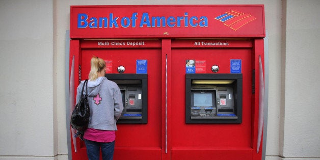 MIAMI, FL - JANUARY 17: A customer uses a Bank of America ATM machine on January 17, 2013 in Miami, Florida. The bank reported a 63 percent drop in fourth-quarter profit after making payments to settle legal claims over its mortgage business. (Photo by Joe Raedle/Getty Images)