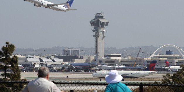 LOS ANGELES, CA - APRIL 22: People watch as a United Airlines jet passes the air traffic control tower at Los Angles International Airport (LAX) during take-off on April 22, 2013 in Los Angeles, California. Delays have been reported throughout the nation because of the furloughing of air traffic controllers under sequestration. The average delay overnight in the Southern California Terminal Radius Approach Control (TRACON) was was three hours. (Photo by David McNew/Getty Images)
