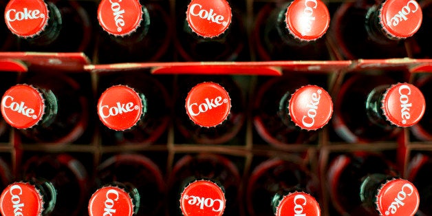 Coca-Cola products sit on display in a supermarket in Princeton, Illinois, U.S., on Thursday, Feb. 27, 2014. Berkshire Hathaway Inc. will probably post record full-year profit showing how Chairman Warren Buffett's five decades of acquisitions positioned his company to benefit from a rebounding U.S. economy. Buffett, 83, gained fame with equity investments in businesses like Coca-Cola Co., which appreciated after his purchases. Photographer: Daniel Acker/Bloomberg via Getty Images