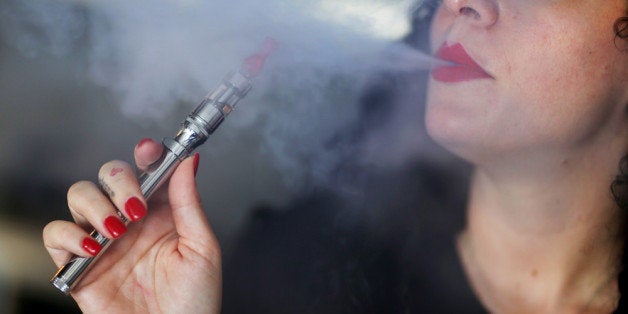 MIAMI, FL - APRIL 24: Julia Boyle enjoys an electronic cigarette as she waits for customers at the Vapor Shark store on Apri