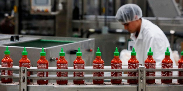Bottles of the Sriracha hot sauce travel down a conveyor belt to be boxed for shipment at the Huy Fong Foods Inc. facility in Irwindale, California, U.S., on Monday, Nov. 11, 2013. A judge denied the city of Irwindale's request for a temporary restraining order and set a hearing for November 22 to determine whether the hot-sauce factory should be shut down while it fixes alleged odor problems. Photographer: Patrick T. Fallon/Bloomberg via Getty Images