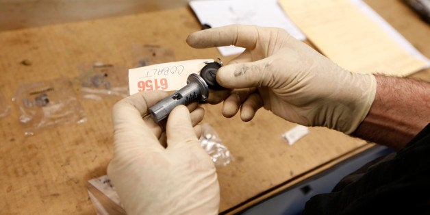 Shop foreman John Chapman installs tumblers for the key cylinder during the service recall on a General Motors Co. (GM) 2005 Chevrolet Cobalt at Liberty Chevrolet in New Hudson, Michigan, U.S., on Friday, April 25, 2014. General Motors is installing thousands of kits consisting of ignition switches, ignition cylinders and key sets for older model small cars subject to a safety recall. Photographer: Jeff Kowalsky/Bloomberg via Getty Images