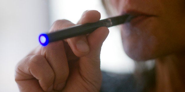 This September 25, 2013 photo illustration taken in Washington, DC, shows a woman smoking an 'Blu' e-cigarette (electronical