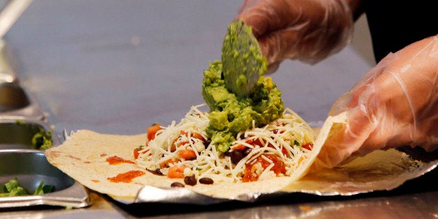 An employee prepares a Chipotle Mexican Grill burrito at the Sunset and Vine store in Hollywood, California, U.S., on Tuesday, July 16, 2013. Chipotle Mexican Grill Inc. is scheduled to release earnings data on July 18. Photographer: Patrick T. Fallon/Bloomberg via Getty Images