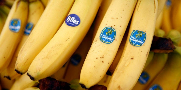 A bunch of Fyffes bananas, grown by Fyffes Plc, left, sits with bunches of Chiquita bananas, grown by Chiquita Brands International Inc., in this arranged photograph taken at a fruit and vegetable stall at an outdoor market in the Lewisham district of London, U.K., on Friday, Aug. 15, 2014. Chiquita, owner of the namesake banana label, said it will continue with its planned purchase of Irish competitor Fyffes after rejecting an unsolicited $611 million takeover proposal from Cutrale Group and Safra Group. Photographer: Simon Dawson/Bloomberg via Getty Images