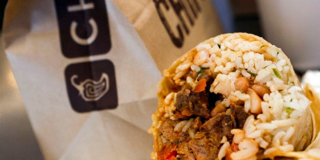 A steak burrito is arranged for a photograph with a drink and bags of chips at a Chipotle Mexican Grill Inc. restaurant in Ho