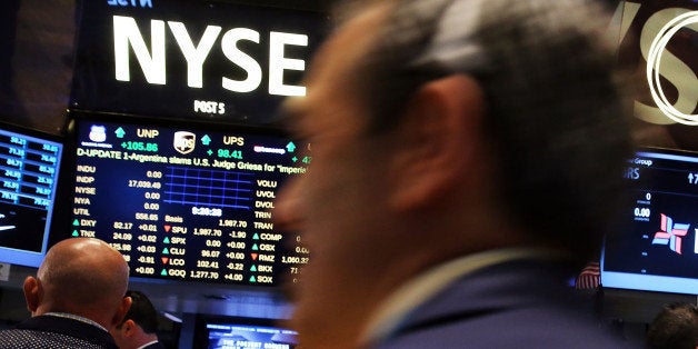 NEW YORK, NY - AUGUST 22: Traders work on the floor of the New York Stock Exchange on August 22, 2014 in New York City. In morning trading the Dow fell 25 points as markets awaited remarks by Federal Reserve chief Janet Yellen. (Photo by Spencer Platt/Getty Images)