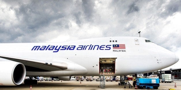 A plane carrying coffins with the remains of victims of Malaysian Airlines flight MH17 sits on the tarmac at Schiphol International Airport in Amsterdam before flying to Malaysia on August 21, 2014. Malaysia will drape itself in black for a national day of mourning on August 22 as it welcomes home the first remains of its 43 citizens killed in the MH17 disaster. The MH17 plane was shot down over rebel-held eastern Ukraine on July 17 en route from Amsterdam to Kuala Lumpur, with the west blaming Russian-backed separatists, while Moscow blames Ukraine. AFP PHOTO / ANP / KOEN VAN WEEL == NETHERLANDS OUT == (Photo credit should read Koen van Weel/AFP/Getty Images)