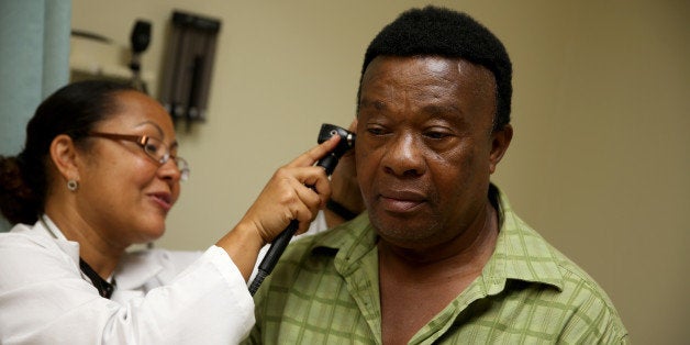 HOLLYWOOD, FL - APRIL 15: Felue Chang who is newly insured under an insurance plan through the Affordable Care Act receives a checkup from Dr. Peria Del Pino-White at the South Broward Community Health Services clinic on April 15, 2014 in Hollywood, Florida. A report released by the Congressional Budget Office indicates that the Affordable Care Act will cost $5 billion less than originally projected for 2014. (Photo by Joe Raedle/Getty Images)