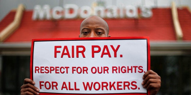 Emmanuel Dawson protests for higher wages outside a McDonalds restaurant in Detroit Thursday, May 15, 2014. Calling for higher pay and the right to form a union without retaliation, fast-food chain workers protested Thursday as part of a wave of strikes and protests in 150 cities across the U.S. and 33 additional countries on six continents. (AP Photo/Paul Sancya)