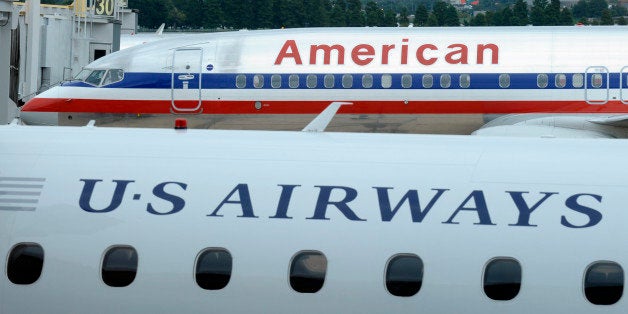 FILE - This Tuesday, Aug. 13, 2013 file photo shows an American Airlines plane and a US Airways plane at parked at Washington's Ronald Reagan National Airport. On Tuesday, Nov. 12, 2013, the Justice Department says it has reached an agreement to allow the merger of the two airlines. The agreement requires them to scale back the size of the merger at key airports in Washington and other big cities. (AP Photo/Susan Walsh)