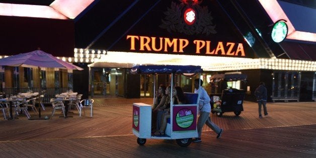 Three women are pushed down the boardwalk in a pushcart outside of Trump Plaza Casino September 15, 2014 in Atlantic City, New Jersey. The Trump Plaza, which opened on May 14, 1984, shut down September 16, 2014, the fourth casino to shutter its doors this year, and a fifth casino, the Trump Taj Mahal, may close if it cannot cut costs of operation. The massive contraction, following years of customer losses to surrounding states, is eliminating 8,000 jobs, or about a quarter of the industry's employment in Atlantic City. AFP PHOTO/Don Emmert (Photo credit should read DON EMMERT/AFP/Getty Images)