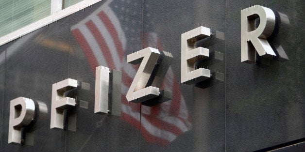 UNITED STATES - JUNE 18: A U.S. flag is reflected in the Pfizer Inc. world headquarters in New York, U.S., on Wednesday, June 18, 2008. Pfizer Inc. rose the most in more than two years after India's Ranbaxy Laboratories Ltd. agreed to keep copies of the cholesterol pill Lipitor off the U.S. market an extra 20 months, protecting $12 billion in sales for Pfizer. (Photo by Andrew Harrer/Bloomberg via Getty Images)