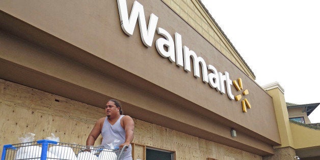 A man pushes a shopping cart outside of a Walmart store that boarded its entrance and closed early in Kailua-Kona, Hawaii, Thursday, Aug. 7, 2014, as the area prepares for Hurricane Iselle. Hurricane Iselle is expected to arrive on the Big Island on Thursday evening, bringing heavy rains, winds gusting up to 85 mph and flooding in some areas. Weather officials changed their outlook on the system Wednesday after seeing it get a little stronger, giving it enough oomph to stay a hurricane as it reaches landfall. (AP Photo/Chris Stewart)