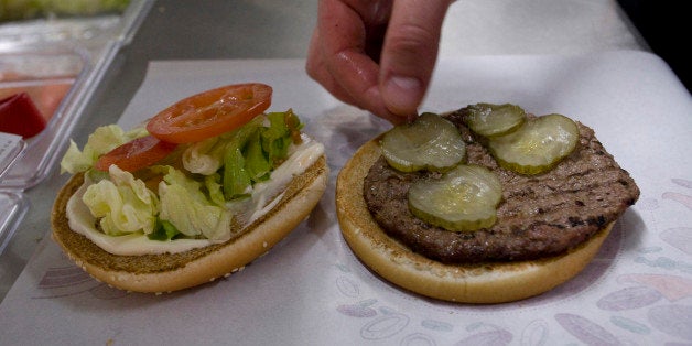 An employee places a pickle in a whopper burger at a Burger King restaurant in Basildon, U.K., on Wednesday, Sept. 8, 2010. Burger King Holdings Inc. agreed to be acquired by 3G Capital, a New York investment firm backed by Brazilian investors, for $3.3 billion in the biggest restaurant acquisition in at least a decade. Photographer: Chris Ratcliffe/Bloomberg via Getty Images