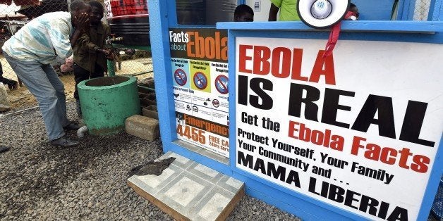 Liberians wash their hands next to an Ebola information and sanitation station raising awareness about the virus in Monrovia on September 30, 2014. Liberia has been hit the hardest by the worst ever outbreak of Ebola, which has killed more than 3,000 people in west Africa. The latest UN data said 1,830 people have died from the killer virus in Liberia so far, and 3,458 people have been infected. AFP PHOTO / PASCAL GUYOT (Photo credit should read PASCAL GUYOT/AFP/Getty Images)