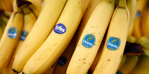 A bunch of Fyffes bananas, grown by Fyffes Plc, left, sits with bunches of Chiquita bananas, grown by Chiquita Brands International Inc., in this arranged photograph taken at a fruit and vegetable stall at an outdoor market in the Lewisham district of London, U.K., on Friday, Aug. 15, 2014. Chiquita, owner of the namesake banana label, said it will continue with its planned purchase of Irish competitor Fyffes after rejecting an unsolicited $611 million takeover proposal from Cutrale Group and Safra Group. Photographer: Simon Dawson/Bloomberg via Getty Images