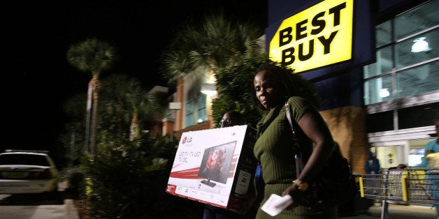 NAPLES, FL - NOVEMBER 29: Black Friday shoppers carry away discounted items from a Best Buy store which opened its doors at 6pm on Thanksgiving Day this year on November 29, 2013 in Naples, Florida. One of the busiest days in the calendar for retailers, over a dozen US stores opened their doors to shoppers one day ahead of the famed-Black Friday shopping day. (Photo by Spencer Platt/Getty Images)