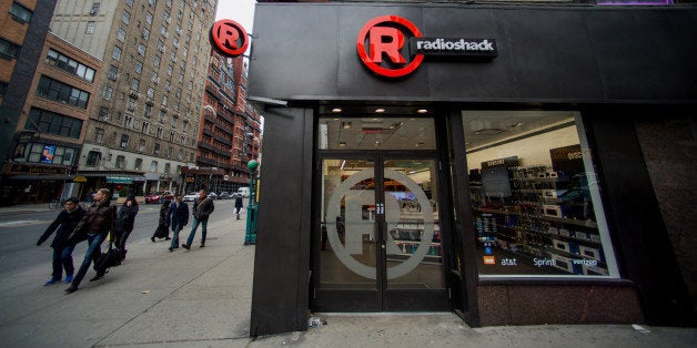 Pedestrians pass in front of a RadioShack Corp. store in New York, U.S., on Sunday, March 2, 2014. RadioShack Corp. is scheduled to release earnings figures on March 4. Photographer: Craig Warga/Bloomberg via Getty Images