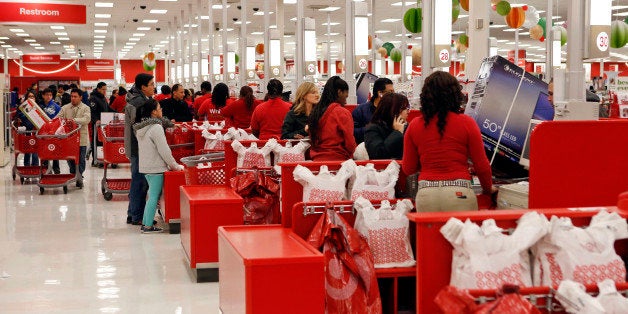 Customers purchase merchandise at a Target Corp. store opening ahead of Black Friday in Chicago, Illinois, U.S., on Thursday, Nov. 28, 2013. U.S. retailers will kick off holiday shopping earlier than ever this year as stores prepare to sell some discounted items at a loss in a battle for consumers. Photographer: Patrick T. Fallon/Bloomberg via Getty Images