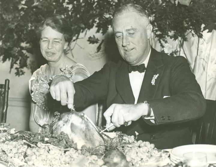 Eleanor Roosevelt watches as the President operates on the big turkey, setting in motion the annual Thanksgiving feast at Warm Springs, Georgia.November 29, 1935.