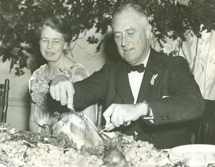 Eleanor Roosevelt watches as the President operates on the big turkey, setting in motion the annual Thanksgiving feast at War