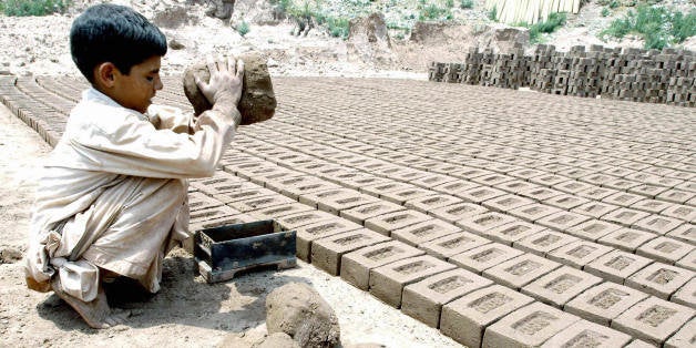 ISLAMABAD, PAKISTAN: Pakistani boy Salim, 7, makes bricks at a brick factory in Islamabad, 12 June 2004. According to the International Labour Organisation, more than half the world's quarter-billion child-labourers work in Asia, often under appalling conditions, facing sexual abuse and even slavery. AFP PHOTO/Farooq NAEEM (Photo credit should read FAROOQ NAEEM/AFP/Getty Images)