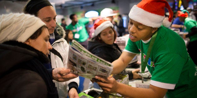 An employee explains sale prices to customers at the Times Square Toys R' Us, Thursday, Nov. 28, 2013, in New York. Instead of waiting for Black Friday, which is typically the year's biggest shopping day, more than a dozen major retailers are opening on Thanksgiving this year. (AP Photo/John Minchillo)