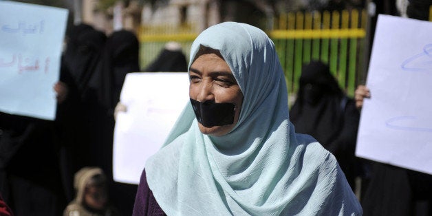 SANAA, YEMEN - NOVEMBER 22: Yemeni woman with adhesive tape over her mouth attends a protest demanding the release of 5 deta
