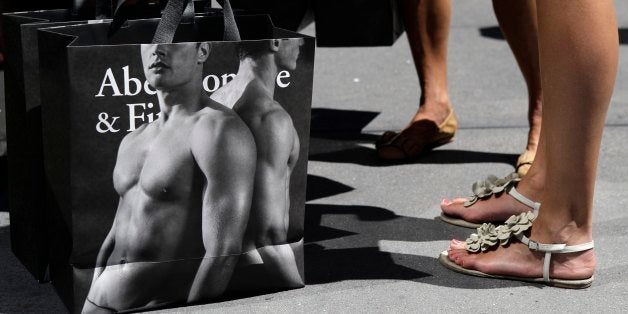 In this Tuesday, July 10, 2012, photo, young women pause with their Abercrombie & Fitch shopping bags on the sidewalk along Fifth Avenue in New York. Hot weather and clearance sales drew Americans into stores in July, giving retailers solid sales gains and helping offset worries about jobs and the economy. (AP Photo/Kathy Willens)