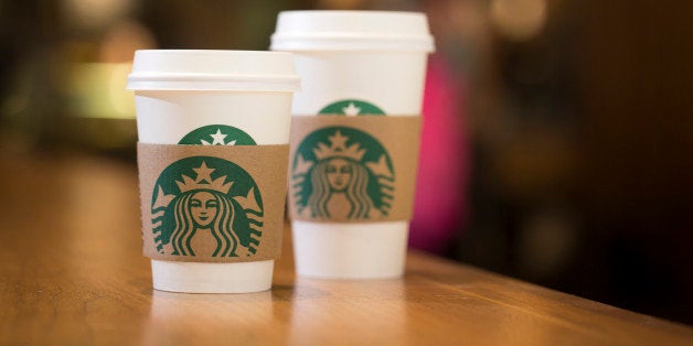 The Starbucks Corp. logo sits on carboard coffee cups inside a Starbucks coffee shop in London, U.K., on Monday, June 9, 2014. U.K. services companies' confidence rose to a record this quarter, indicating continued expansion in the largest part of the economy, the Confederation of British Industry said. Photographer: Jason Alden/Bloomberg via Getty Images