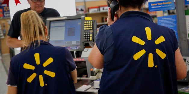 Employees assist shoppers at the check out counter of a Wal-Mart Stores Inc. location ahead of Black Friday in Los Angeles, California, U.S., on Monday, November 24, 2014. Retailers are planning to open earlier on Thanksgiving day this year in a bid to draw shoppers. Wal-Mart Stores Inc. is making Black Friday, the shopping day after Thanksgiving, a weeklong event this year. Photographer: Patrick T. Fallon/Bloomberg via Getty Images