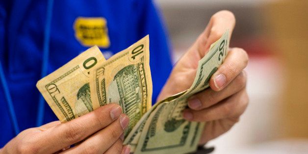A Best Buy Co. employee counts U.S. twenty and ten dollar banknotes at a Best Buy Co. store ahead of Black Friday in San Francisco, California, U.S., on Thursday, Nov. 27, 2014. An estimated 140 million U.S. shoppers will hit stores and the Web this weekend in search of post-Thanksgiving discounts, kicking off what retailers predict will be the best holiday season in three years. Photographer: David Paul Morris/Bloomberg via Getty Images