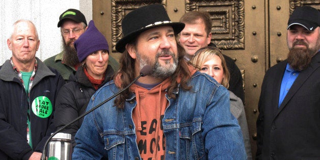 Vermont folk artist Bo Muller-Moore speaks Friday Dec. 12, 2014 outside the Vermont Statehouse in Montpelier about his winning a legal fight to trademark the phrase "eat more kale" despite initial opposition from fast food giant Chick-fil-A, which sought to protect its phrase "eat mor chikin." Muller-Moore said his three-year-legal battle for trademark protection is a victory for the little guy over a corporate giant. (AP Photo/Wilson Ring)