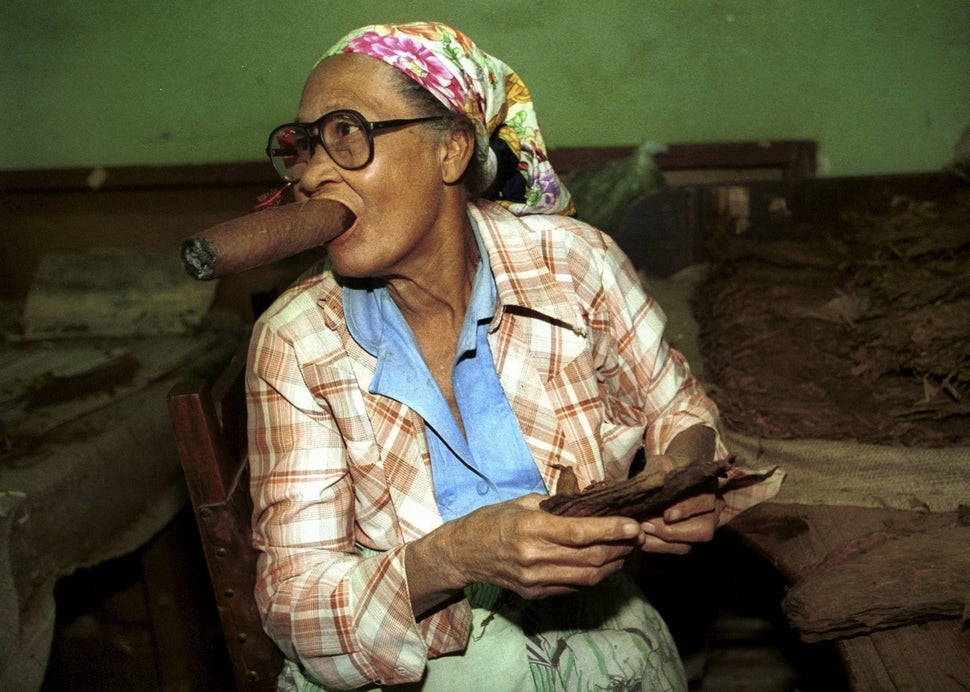 Date unknown - An old woman smokes an oversize cigar while working cigar maker Partagas in the Cuban capital Havana.
