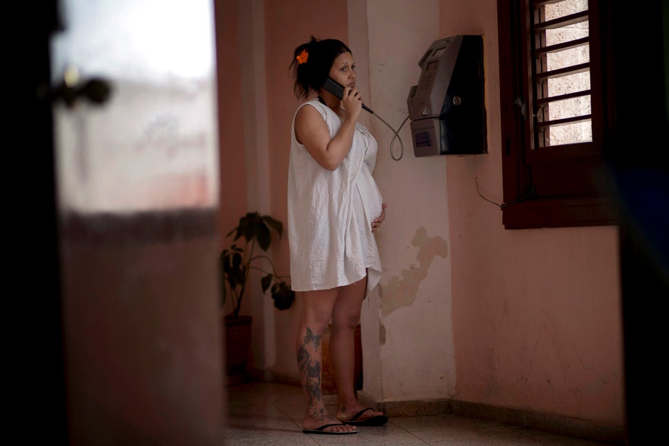 2014 - A pregnant woman holds her belly while she talks on a public phone at a special maternity unit for high-risk pregnanci