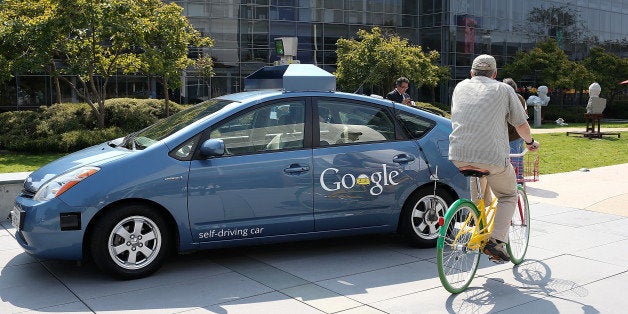 MOUNTAIN VIEW, CA - SEPTEMBER 25: A bicyclist rides by a Google self-driving car at the Google headquarters on September 25,