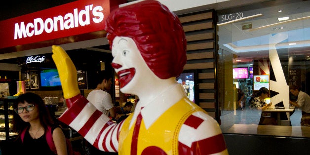 FILE - In this Thursday, July 31, 2014 file photo, a customer walks past a statue of Ronald McDonald on display outside a McDonald's restaurant in Beijing. McDonald's Corp. on Monday, Nov. 10, 2014 said that a key global sales figure slipped 0.5 percent in October, with weakness in the U.S. and ongoing difficulties from a food-safety scandal in China weighing down its business. (AP Photo/Andy Wong, File)