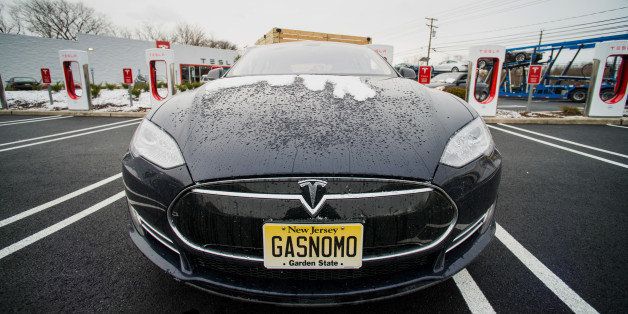 A Model S electric vehicle (EV) with a personalized license plate charges at a supercharger station at the Tesla Motors Inc. Gallery and Service Center in Paramus, New Jersey, U.S., on Thursday, Dec. 11, 2014. Tesla rose 1.2 percent at the end of trading mid last week to close at $216.89 after falling as low as $204.27. For the year, the shares have gained 44 percent. Photographer: Ron Antonelli/Bloomberg via Getty Images